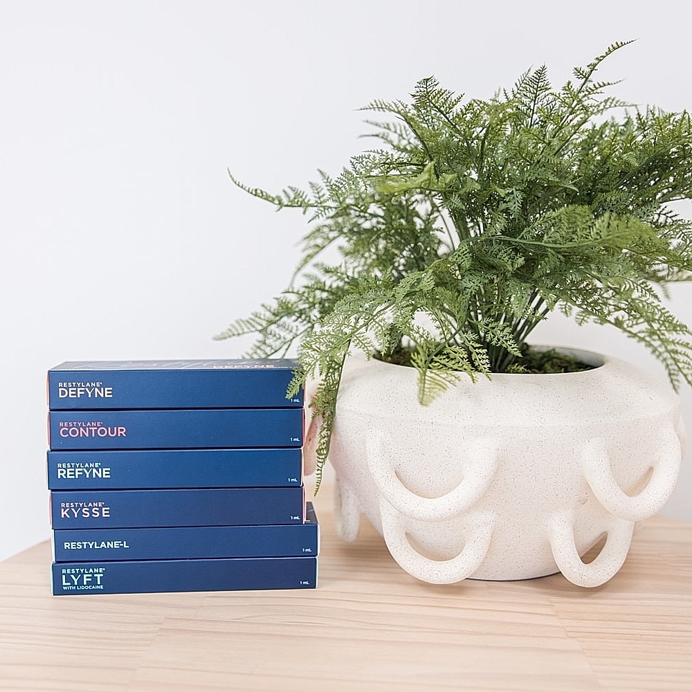 Restylane products beside a decorative plant pot.