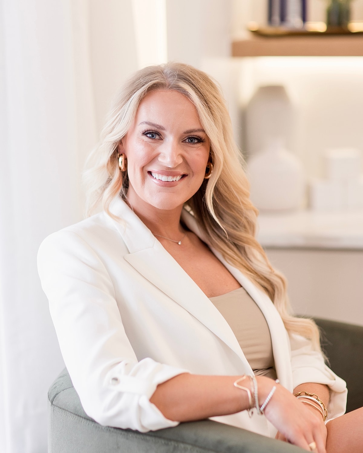 Smiling person in a white blazer relaxing.