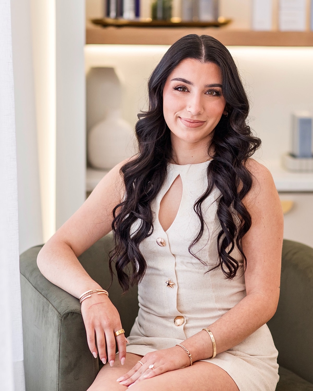 Woman with long hair sitting in a chair.