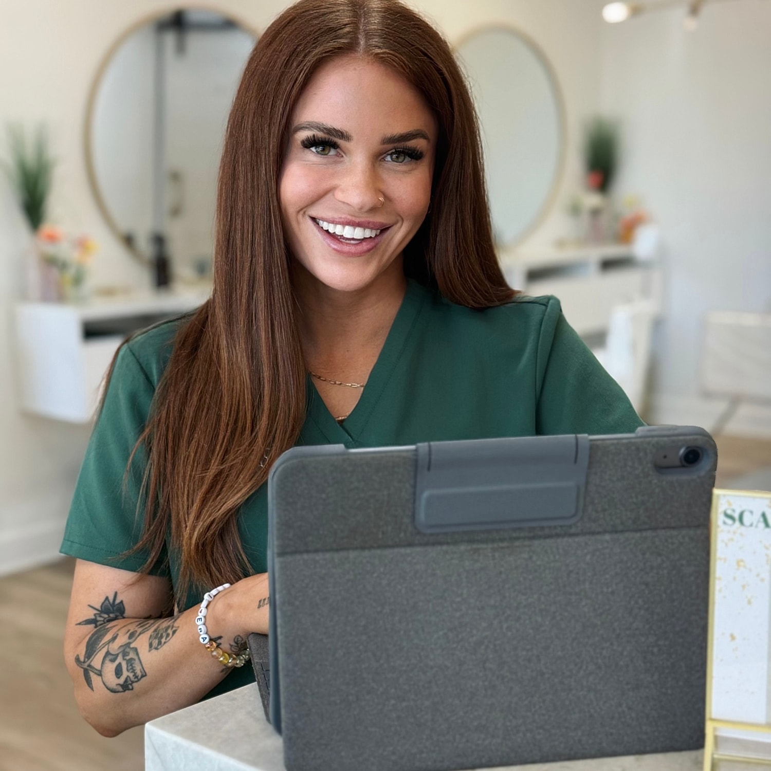 Woman on phone at reception desk, smiling.