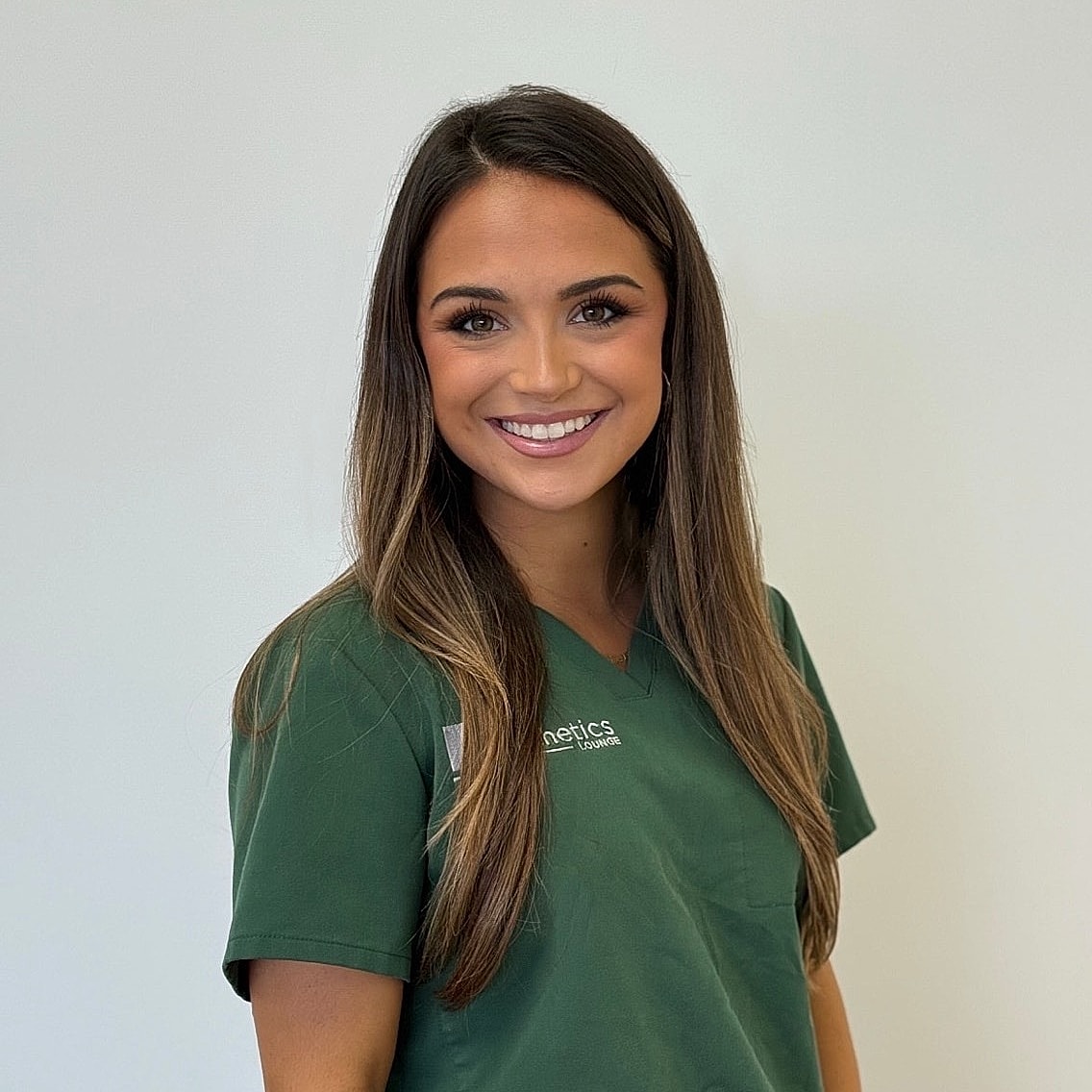Smiling woman in green medical scrubs.