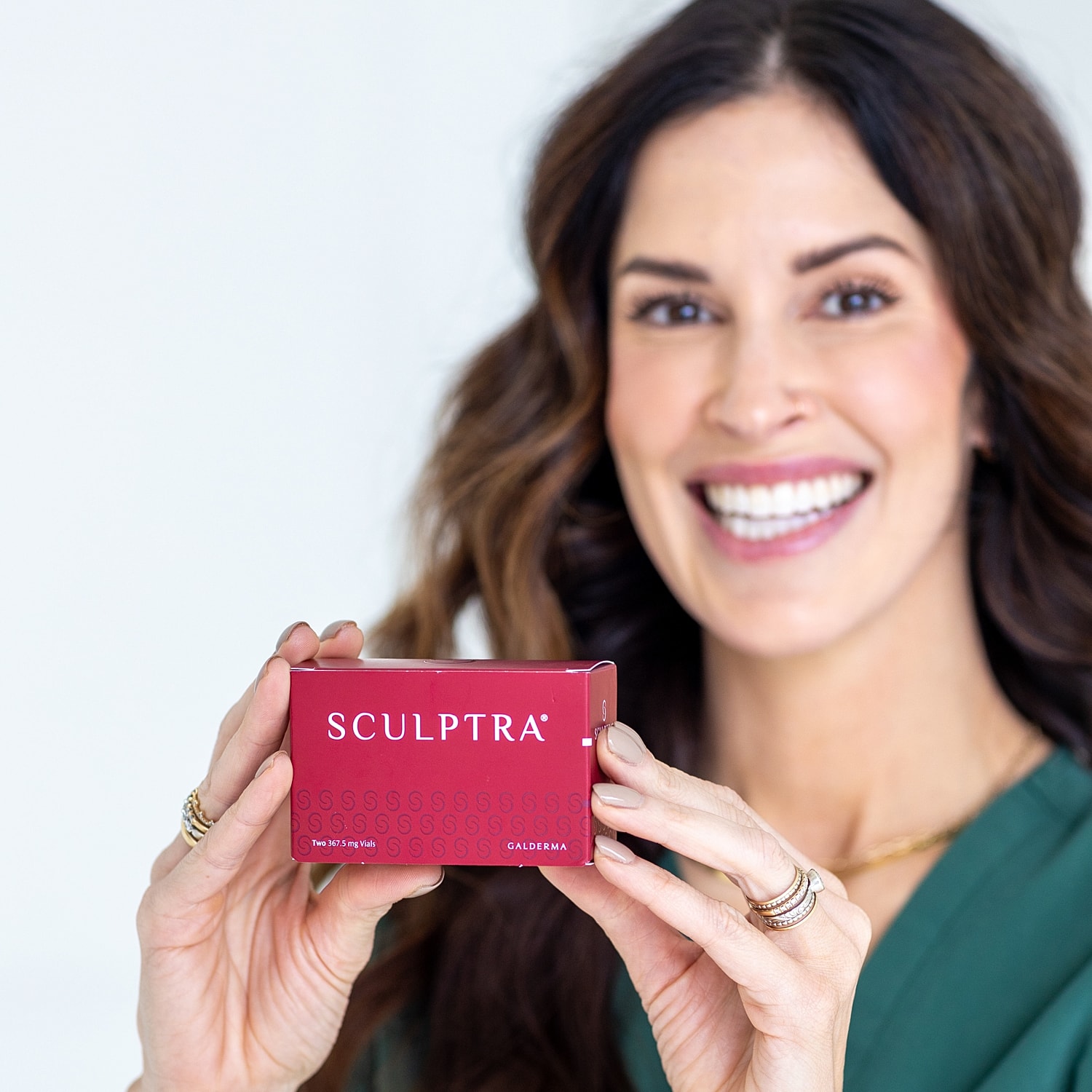 Smiling woman with long hair against white background.