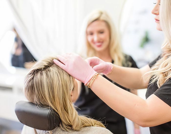 Hair treatment at a salon with stylists.