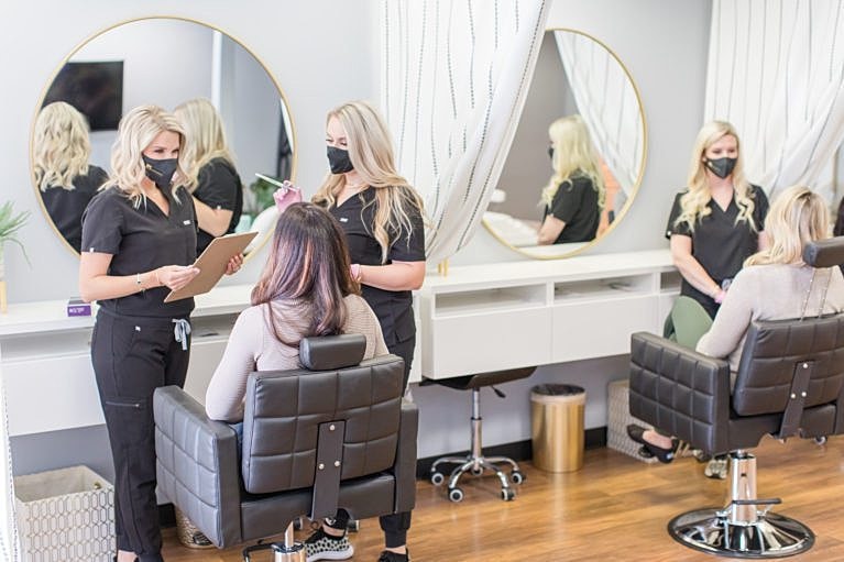 Beauty salon consultation with stylists and clients.