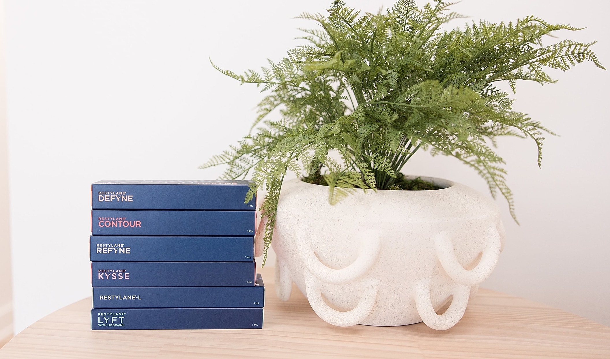 Restylane products beside a decorative plant.